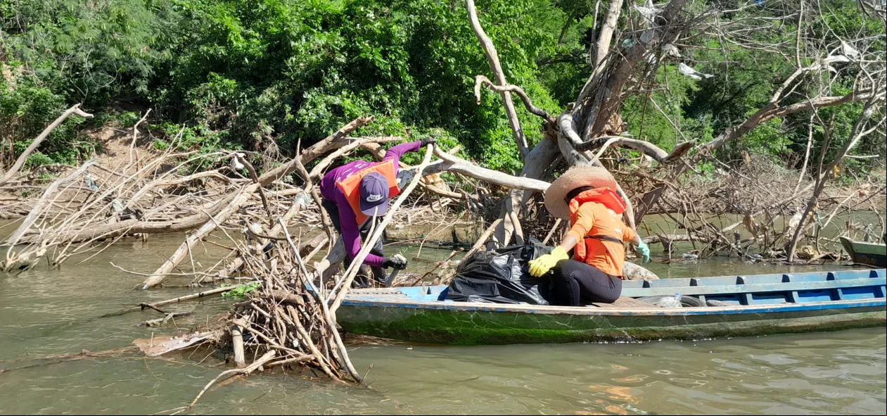Pescadores realizando a coleta do lixo